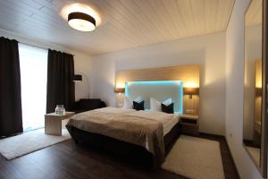 a bedroom with a large bed with a blue headboard at Der Wieshof in Riedlhütte