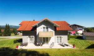 a large white house with red roofs at Der Wieshof in Riedlhütte