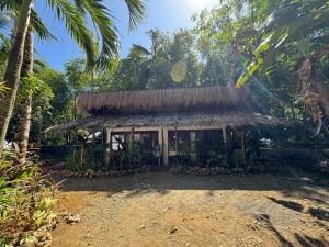 a hut in the middle of a forest with palm trees at NUTMEG Cottage Siargao- Private room in General Luna