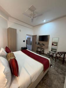 a bedroom with a large bed and a television at A One Residency in Bahora