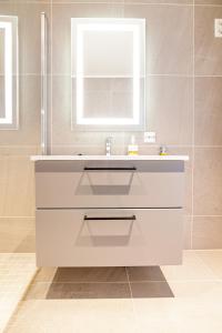 a bathroom with a white sink and a mirror at Villa Lofoten balcony view in Ballstad +37 photos