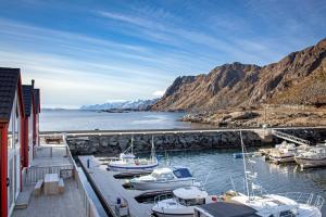 a group of boats docked at a dock in the water at Villa Lofoten balcony view in Ballstad