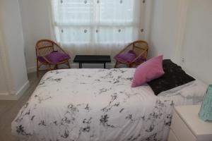 1 dormitorio con 1 cama, 2 sillas y ventana en Apartamento Luceros, en Alicante