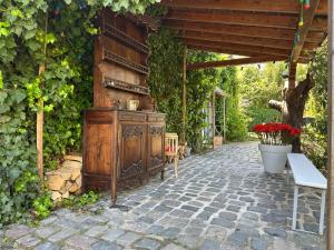 an outdoor patio with a wooden dresser and a bench at L'atelier au jardin in Strasbourg