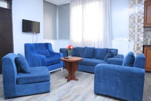 a living room with blue couches and a table at yellow apple hotel in Addis Ababa