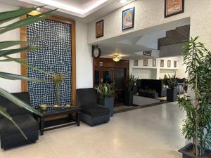 a lobby with potted plants and a clock on the wall at Hotel Yadu Residency in Meerut