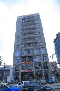a tall building with cars parked in front of it at yellow apple hotel in Addis Ababa
