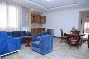 a living room with blue couches and a table at yellow apple hotel in Addis Ababa
