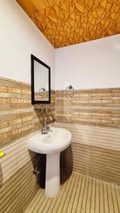 a bathroom with a sink and a mirror at Dolma Homestay By Orko in Nachar
