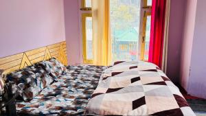 a bed sitting in a room with a window at Dolma Homestay By Orko in Nachar