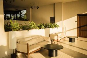 a living room with a couch and tables and plants at Hotel Punta Bermeja Premium in El Puerto de Santa María