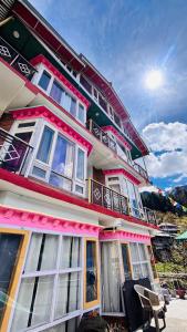 a building with pink and white windows on it at Dolma Homestay By Orko in Nachar