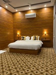 ein Schlafzimmer mit einem großen Bett und Holzwänden in der Unterkunft Hotel Vintique in Lahore