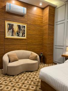 ein Wohnzimmer mit Sofa und Bett in der Unterkunft Hotel Vintique in Lahore