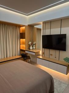 a bedroom with a large bed and a flat screen tv at Resorts World Eighty One Newport Boulevard Near Airport T2 and T3 in Manila