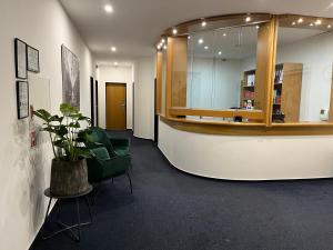 a lobby with a green chair and a table at Penzion Luna in Brno
