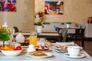 a table topped with plates of breakfast foods and orange juice at Relais VILLA CAIA in Noto