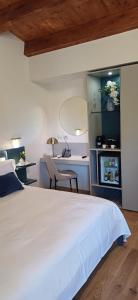 a bedroom with a white bed and a desk at Relais VILLA CAIA in Noto