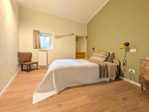 a bedroom with a bed and a chair and a window at Borgo Mare in Piombino
