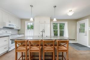 a kitchen with a large kitchen island with four chairs at Ideal getaway - Ideal retreat in Lac-Brome