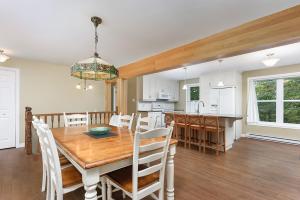 a dining room and kitchen with a wooden table and chairs at Ideal getaway - Ideal retreat in Lac-Brome