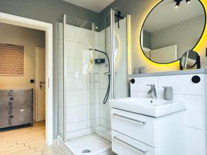a bathroom with a sink and a shower with a mirror at Wohnung Koje ³ in Böhl +14 photos