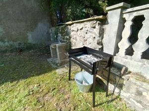 a grill sitting in the grass next to a wall at La Casona de Ilusión in Solórzano