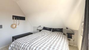 a bedroom with a bed with a checkered blanket at Wohnung Koje ³ in Böhl