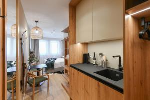 a kitchen with a black counter top and a bedroom at Hotel Monínec - Depandance Apartmány in Moninec