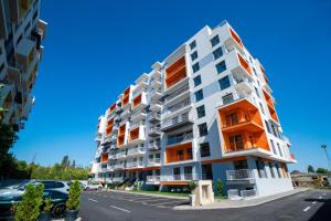 an apartment building with orange windows in a parking lot at Real Resort in Ploieşti