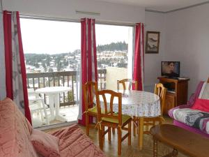 a living room with a table and chairs and a balcony at SPACIEUX STUDIO 3 étoiles SUR BOLQUERE PYRENEES 2000 in Font-Romeu