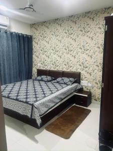 a bedroom with a bed in a room with wallpaper at The Aura stays in Indore