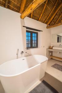 a large white tub in a bathroom with a sink at De Wildeveldt in Darling +36 photos