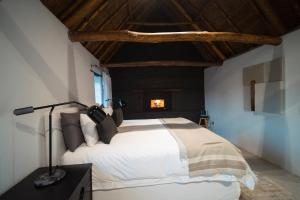 a bedroom with a bed with a lamp on a table at De Wildeveldt in Darling