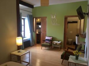 a living room with green walls and a couch and a chair at T'nature à Château Chalon in Château-Chalon