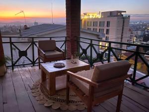 a balcony with a table and chairs on top of a building at M'Serenity Guest House in Antananarivo