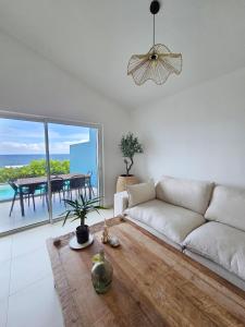 a living room with a white couch and a table at Villa Aura in Oyster Pond