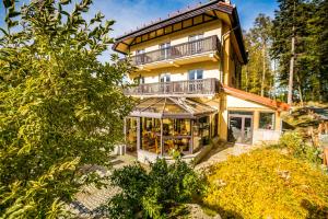 a large yellow house with a balcony at Nowa - Ski SPA Hotel in Karpacz