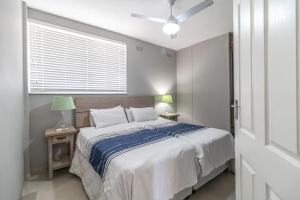 a bedroom with a large bed and a window at Albetros 904 in Amanzimtoti