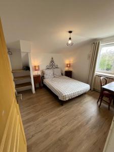 ein Schlafzimmer mit einem Bett, zwei Tischen und einem Fenster in der Unterkunft Raiv in Lectoure