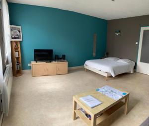 a bedroom with a bed and a tv and a table at Chez Mimi in Châtillon-sur-Seine