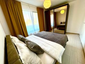 a bedroom with a bed with pillows and a mirror at DAV apart in Otopeni