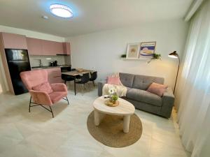 a living room with a couch and a table at Nikol's central suite 1 in Nea Peramos +19 photos