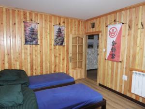 a room with wooden walls and blue beds in it at Pokoje pod Turbaczem in Ostrowsko