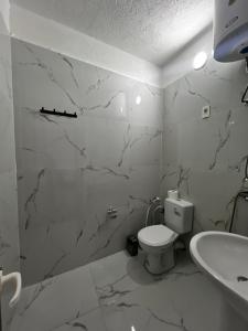 a white bathroom with a toilet and a sink at ApartHotel XH in Golem