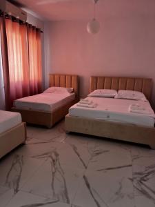 two beds in a room with a marble floor at ApartHotel XH in Golem