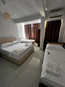 a hotel room with two beds and curtains at ApartHotel XH in Golem