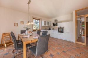 a kitchen and dining room with a table and chairs at Ferienwohnung Krebs in Loddin