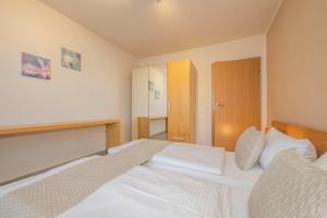 a bedroom with a large white bed in it at Ferienwohnung Krebs in Loddin