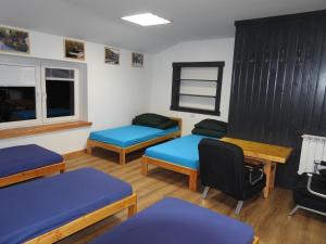 a room with three beds and a table and a desk at Pokoje pod Turbaczem in Ostrowsko